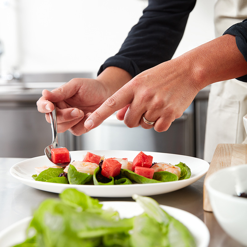 chef hands preparing watermelon salad